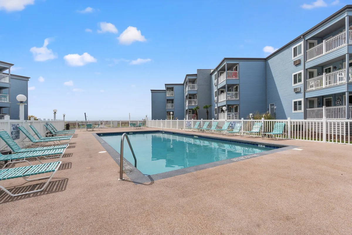 A sparkling swimming pool surrounded by lounge chairs and nearby buildings, set in a relaxed outdoor environment. The area invites socializing, swimming, and sunbathing—perfect for afternoon family barbecues or cooling off after a busy day of adventure.